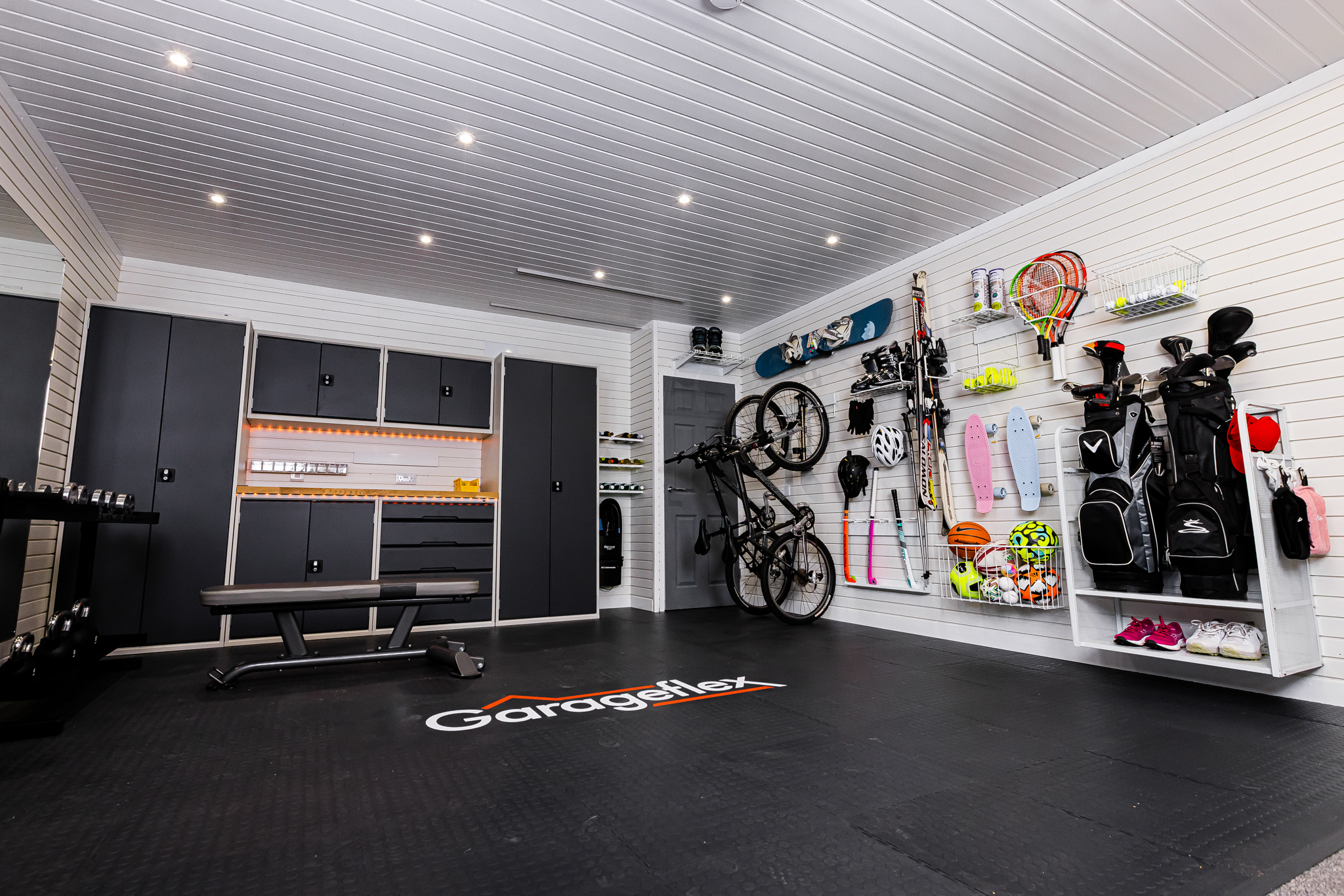 A garage with bike rack and storage racks on the wall and metal cabinets on the other wall.